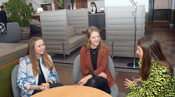 Tre unge omkring et rundt bord